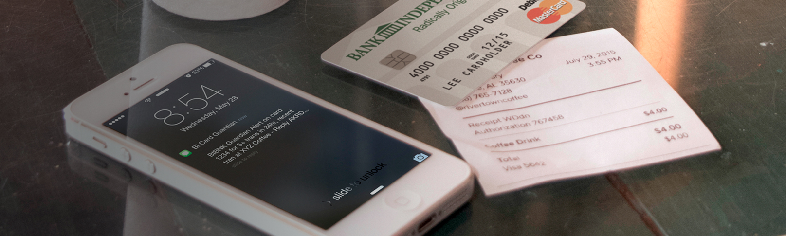 Card Guardian alert on phone sitting on a green table