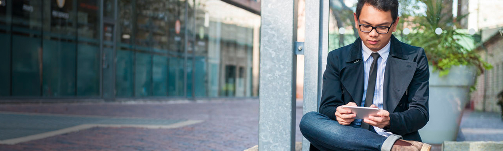 A business man sits outside on his cellphone