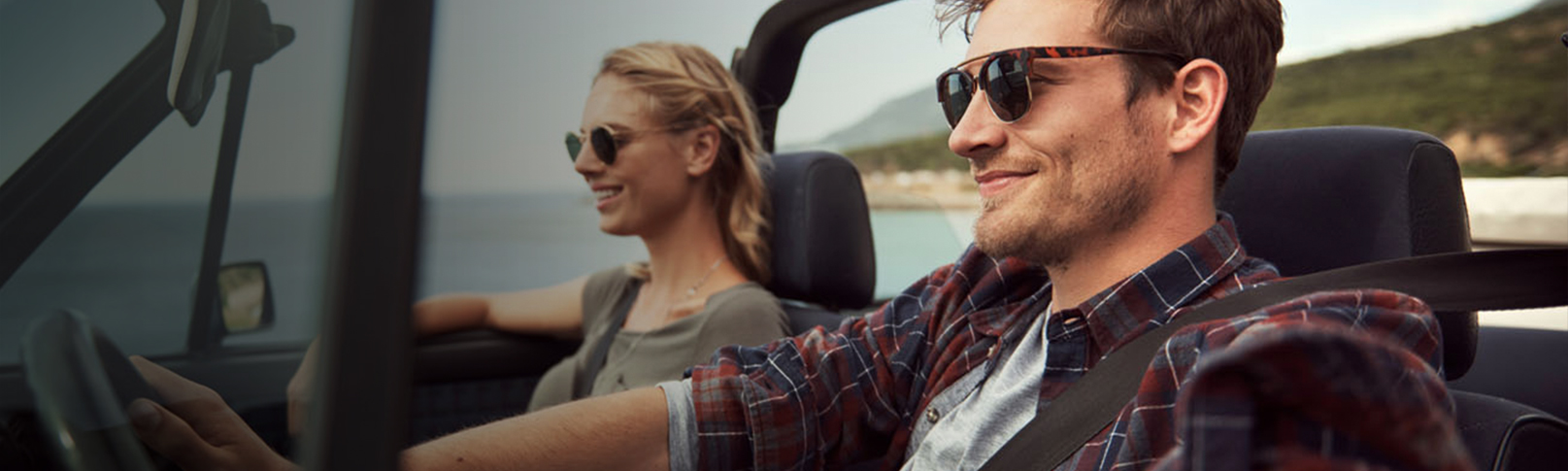 young couple driving in a convertible