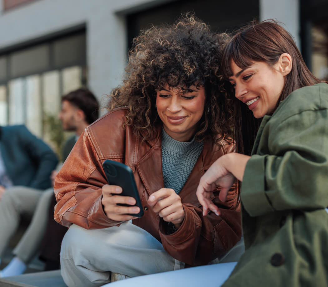 Two female friends look at mobile phone