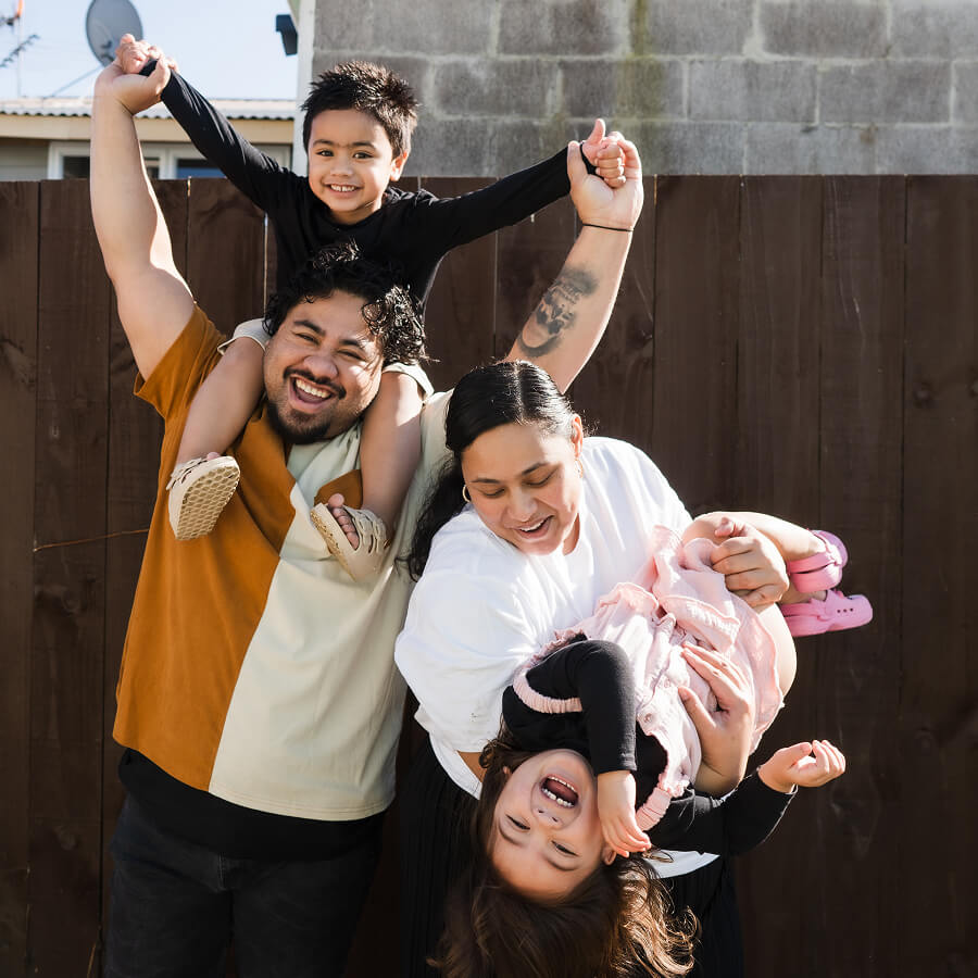 Young family of 4 pose outdoors