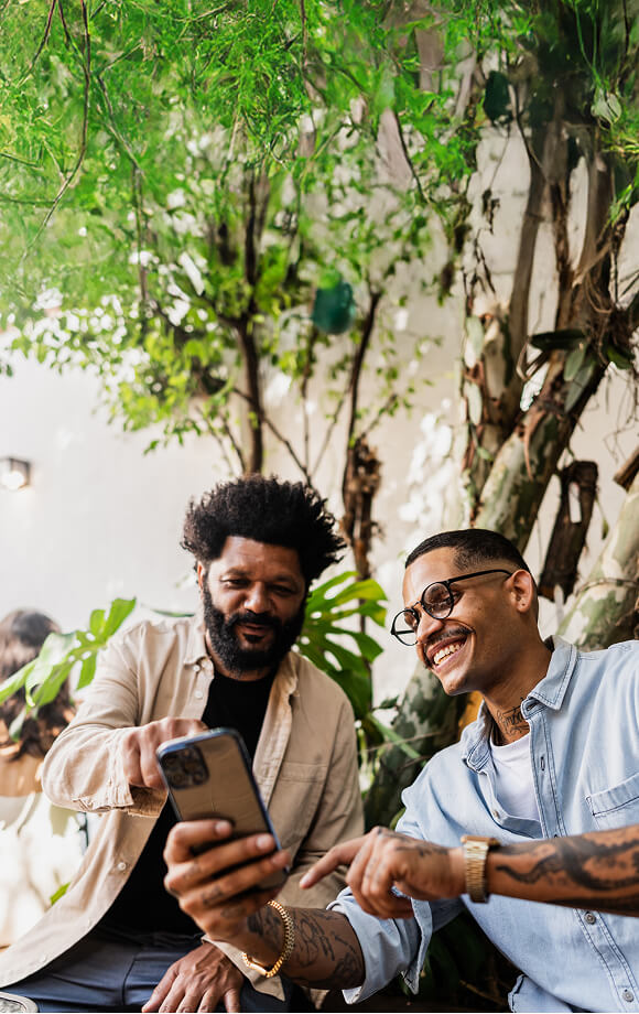 Two friends look at a mobile phone