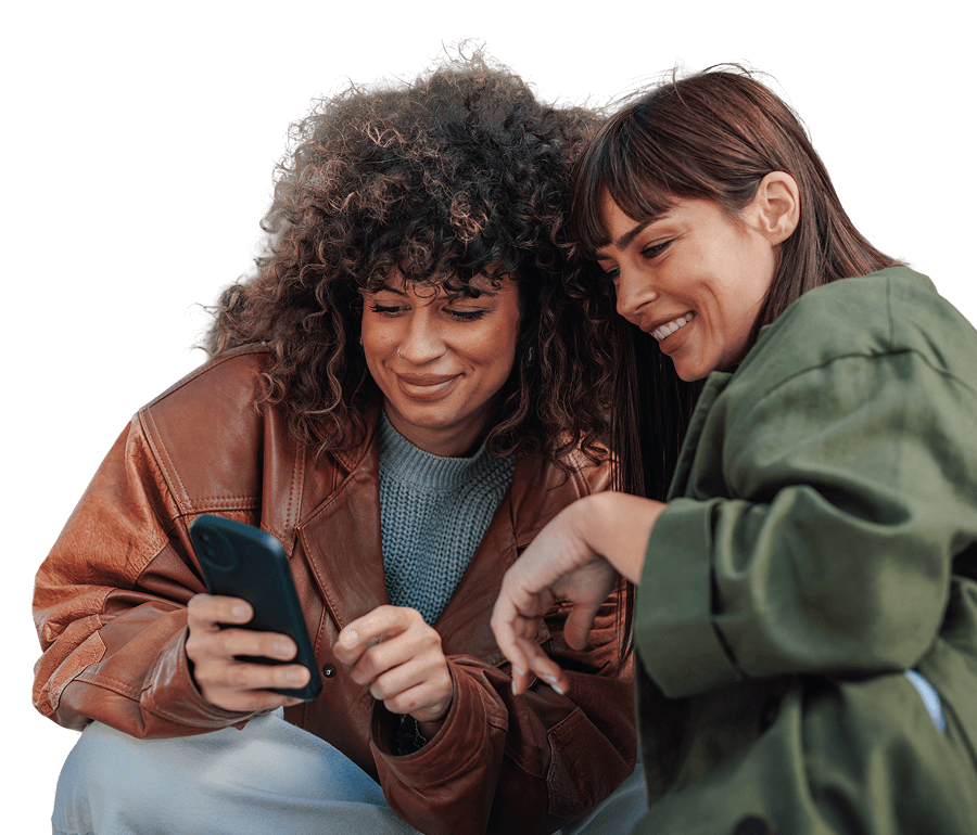 Young female friends looking at mobile phone